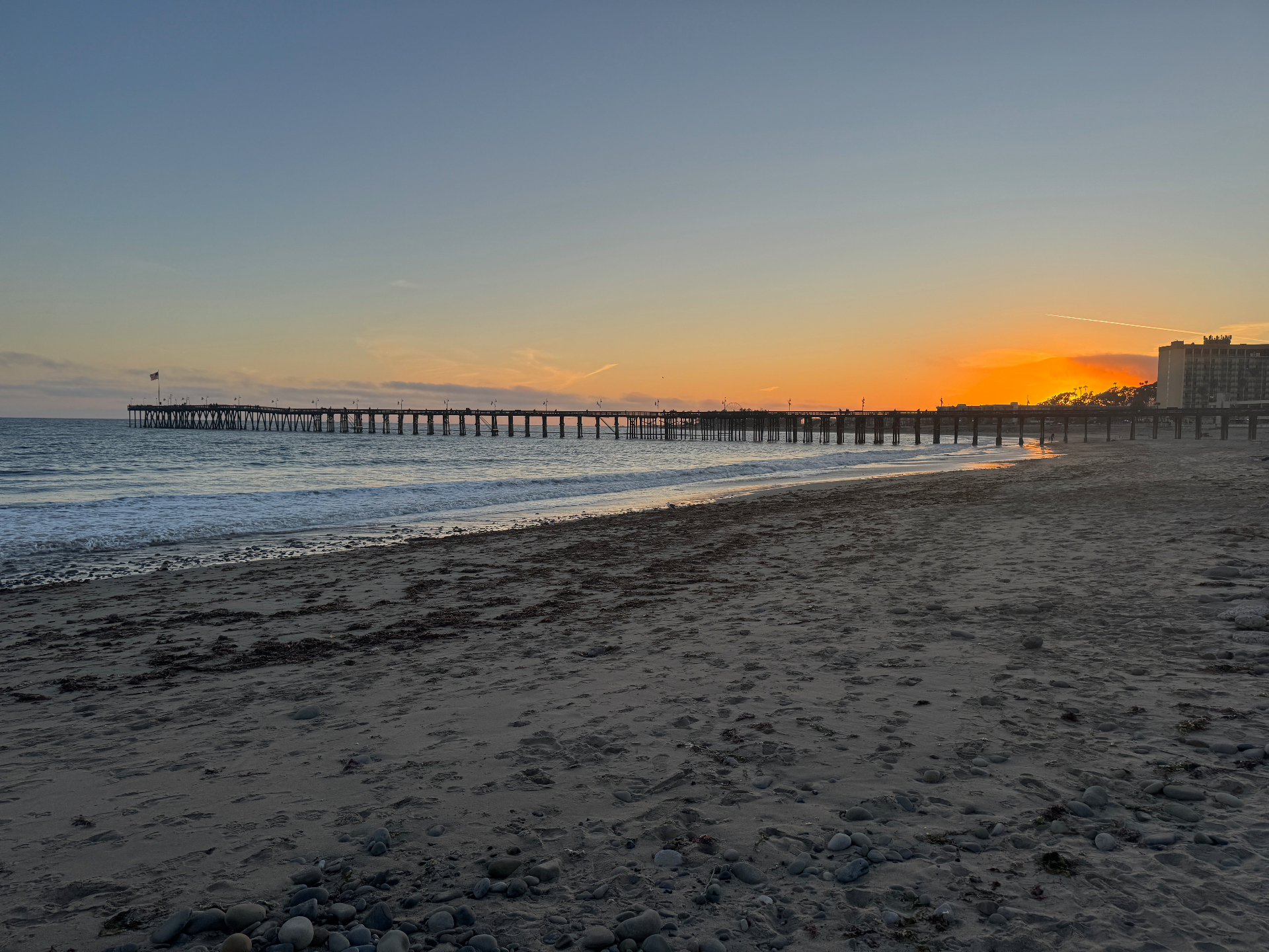 Ventura Pier at sunset with golden beach and coastal buildings - professional house cleaning services available throughout Ventura CA including Pierpont Bay, downtown historic district, and beachfront properties near the pier