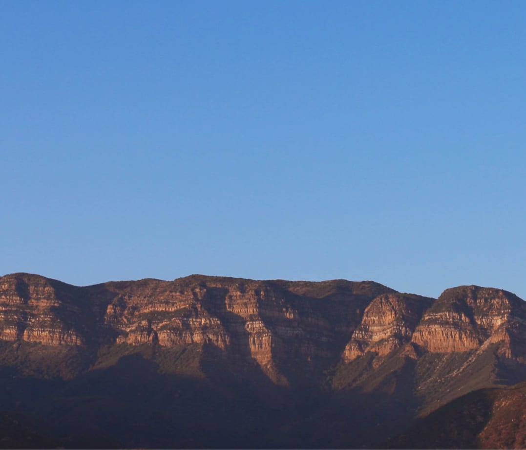 Ojai Valley Topa Topa Mountains with dramatic layered sandstone formations and blue sky - professional house cleaning services for mountain homes, artist studios, spiritual retreats, and vacation rentals throughout Ojai CA including downtown Ojai, East End, Arbolada, and Meiners Oaks neighborhoods